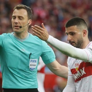 Schiri Felix Zwayer und Deniz Undav vom VfB Stuttgart gestikulieren.