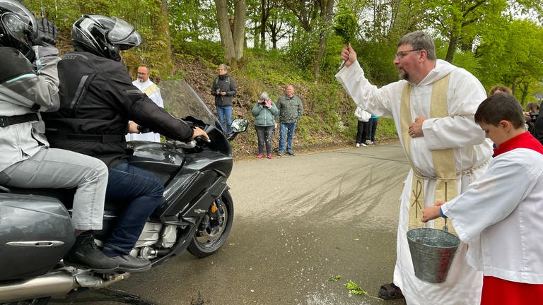 Pater Albert segnet Motorradfahrer in Klausen. (Foto: SWR)